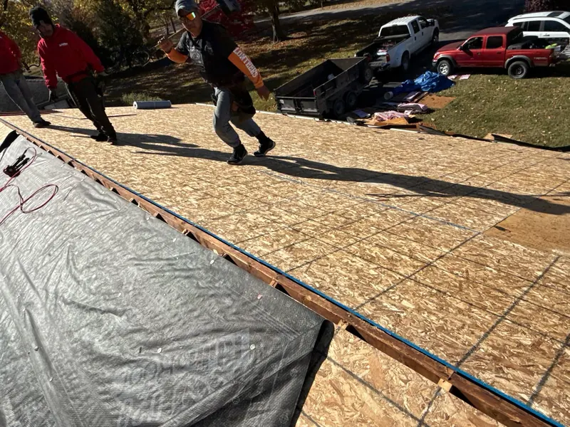 Multi-Family Roofing crew working on a bare roof deck during a tear-off