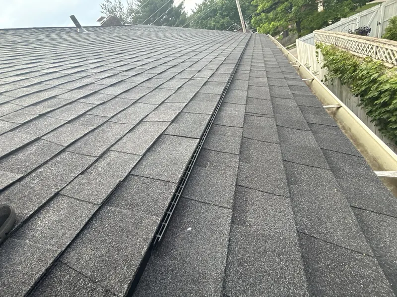 Close-up of straight shingle courses and a clean ridge after repair work