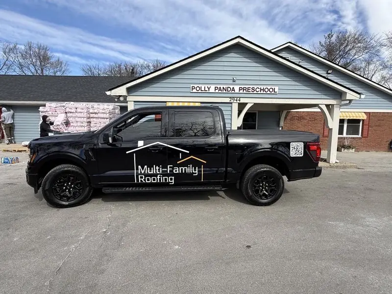 Multi-Family Roofing truck and insulation materials staged at a commercial building