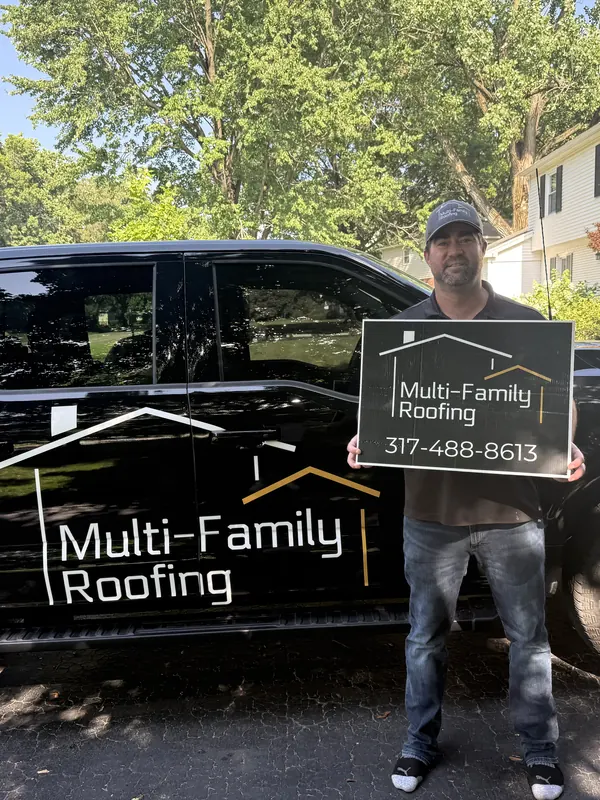 Scott Mason, owner of Multi-Family Roofing LLC, beside the company truck